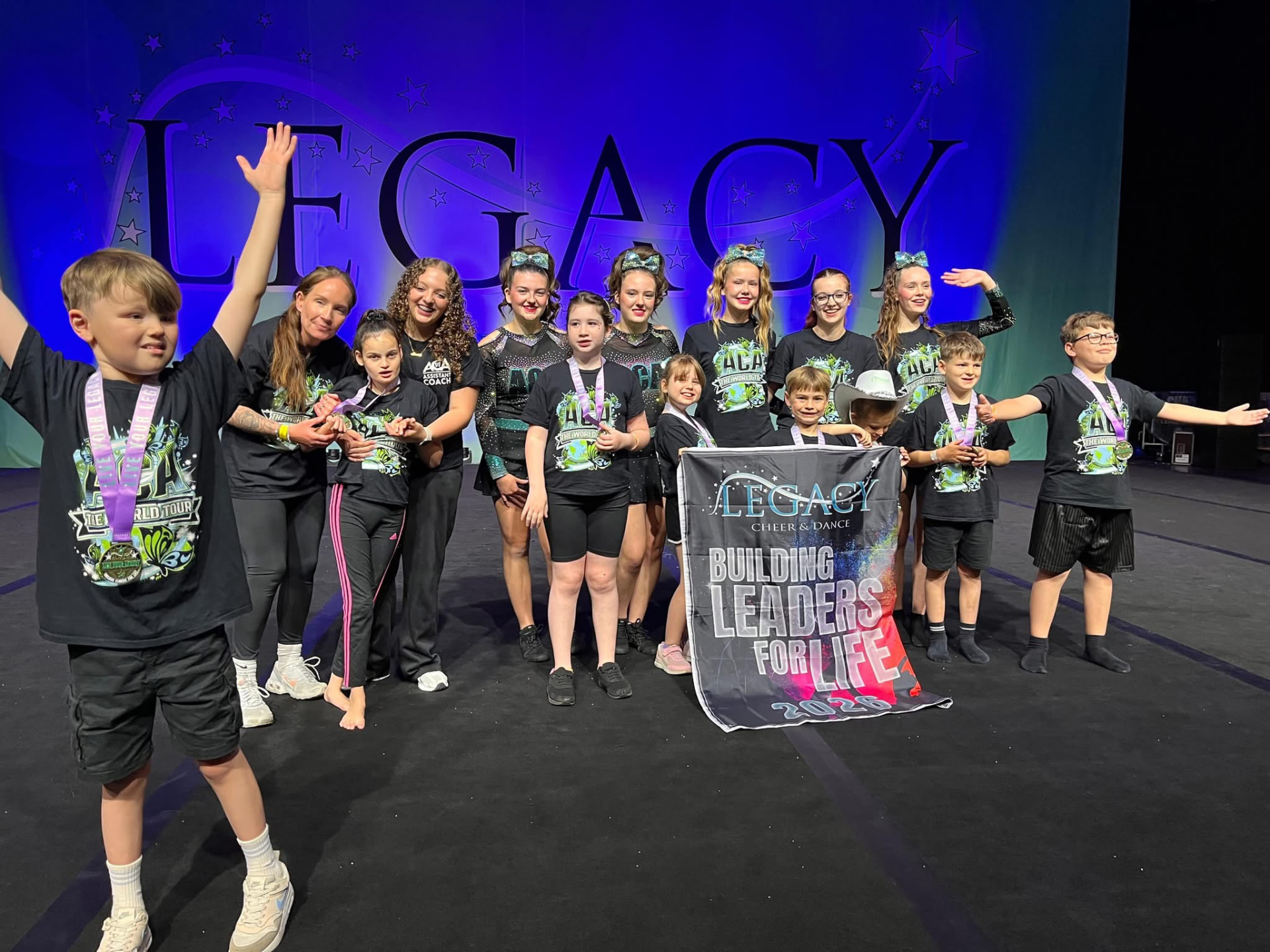 ACA Limitless team celebrating on stage with their coaches