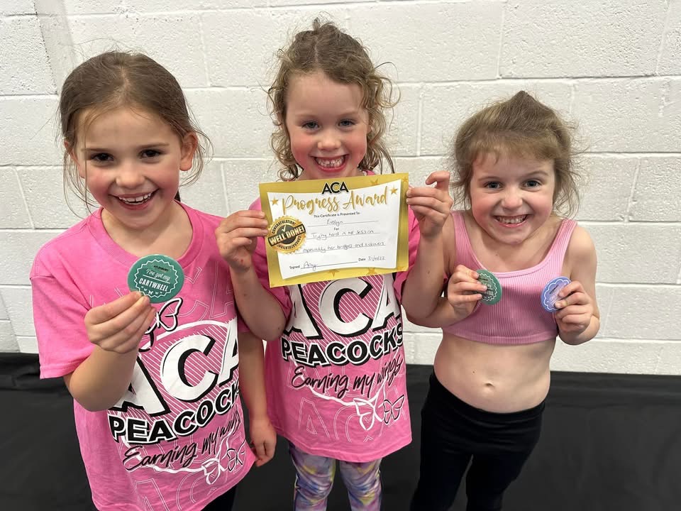 Young ACA members celebrating with progress awards and cartwheel badges